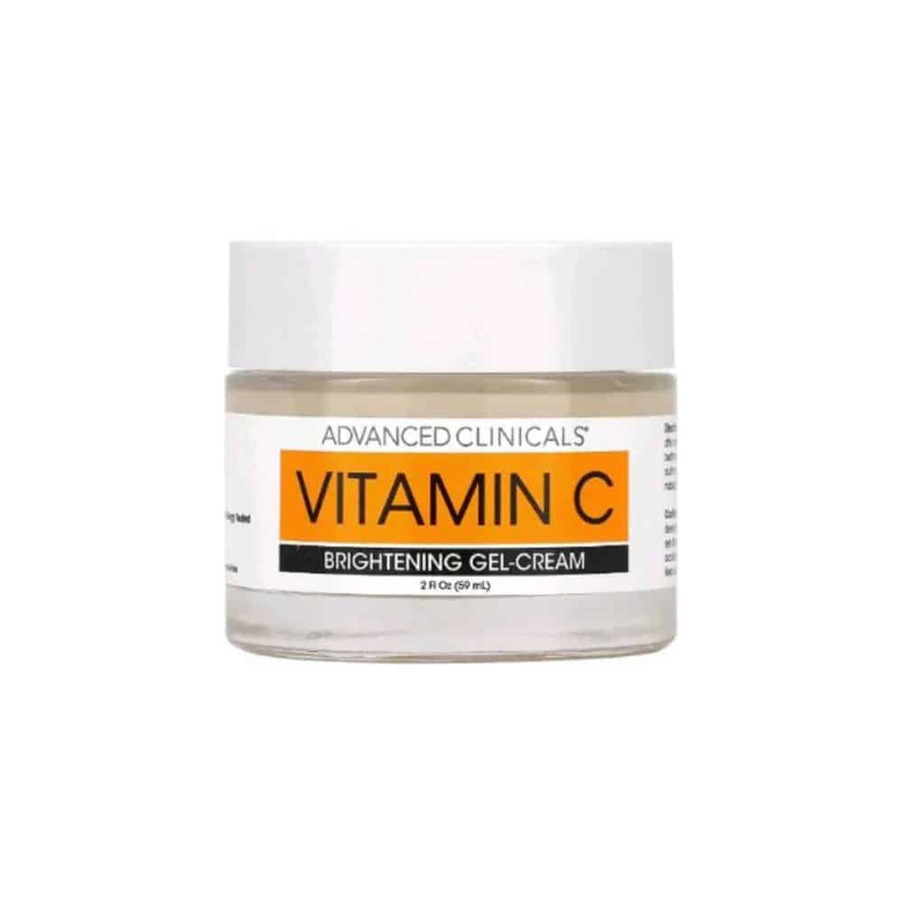 Advanced Clinicals Vitamin C Brightening Face Gel-Cream in minimalist orange-and-white packaging on a white background. The jar is open, showing a smooth gel-cream texture. A hand applies the product to glowing cheekbones, emphasizing its lightweight, fast-absorbing formula ideal for humid climates.