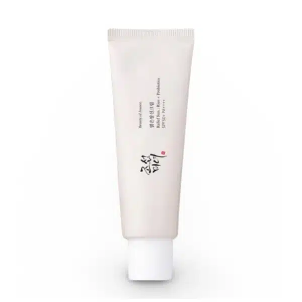 Front view of Beauty of Joseon Relief Sun Rice + Probiotics SPF50 PA++++ sunscreen tube (50ml) on white background. Gold Korean text accents the white packaging, with visible labels: "30% Rice Extract," "Probiotics," and "SPF50+ PA++++." A pearl-sized dollop of the creamy, off-white formula is shown blending seamlessly into skin
