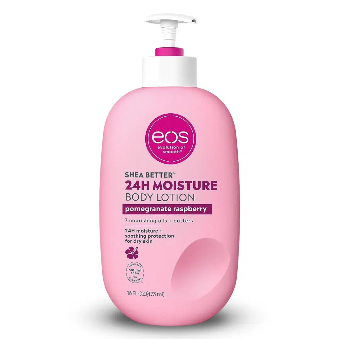 White-background product photo of a 16 fl oz bottle of Eos Shea Better 24H Moisture Body Lotion in the Pomegranate Raspberry variant. The sleek pump bottle features pink and white branding, shea nut graphics and text highlighting 24-hour hydration with shea butter and shea oil.