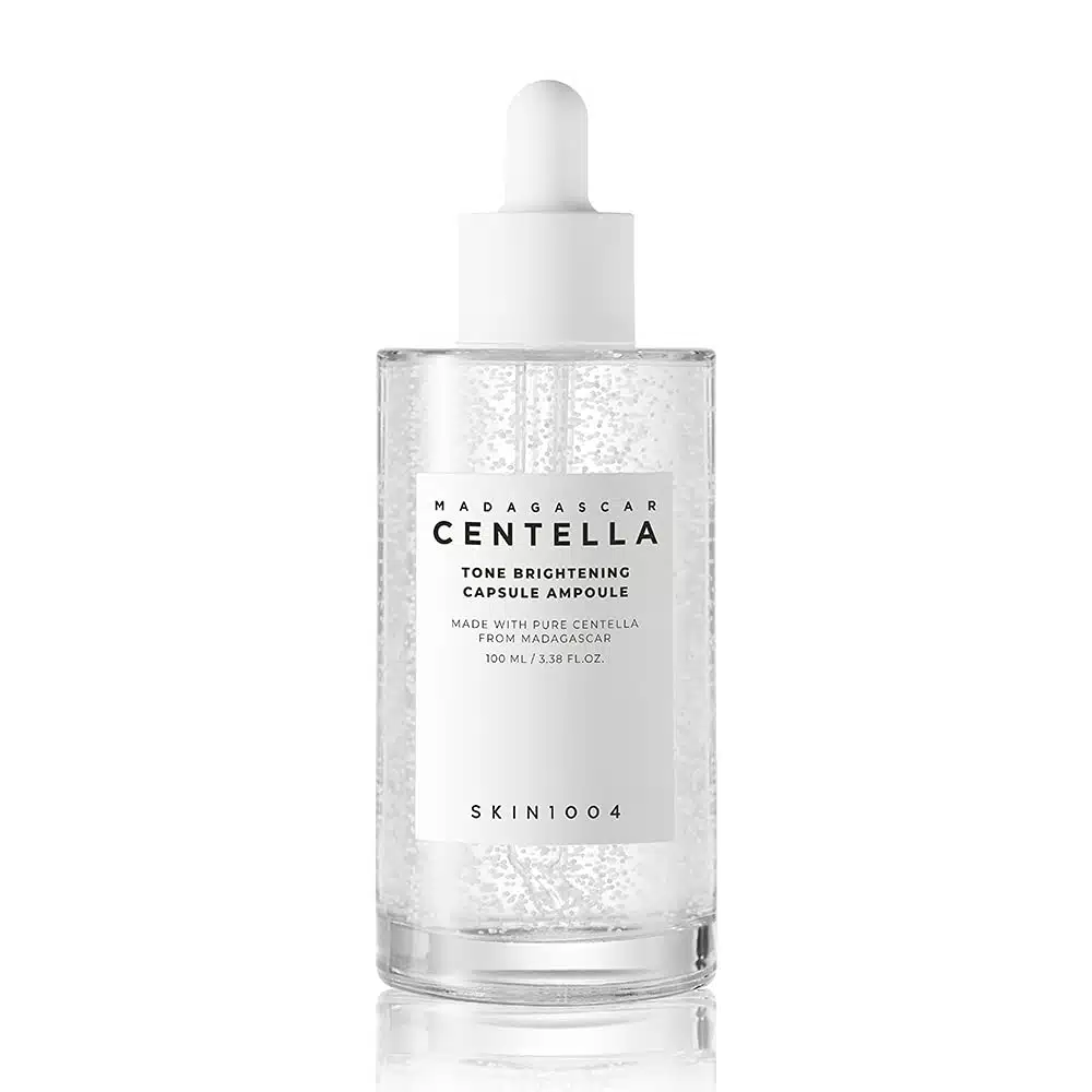 SKIN1004 Madagascar Centella Tone Brightening Capsule Ampoule 50ml—clear bottle with dropper, containing a lightweight, transparent serum with micro-beads, designed to brighten and soothe skin.