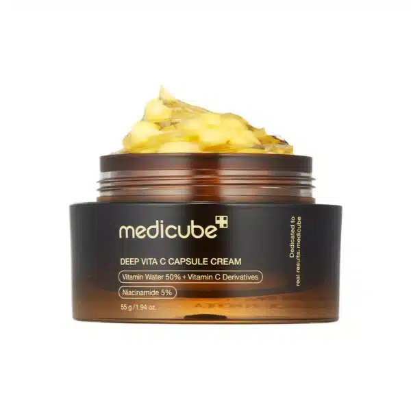 Open jar of Medicube Deep Vita C Capsule Cream 55 g on white background, showing translucent gel studded with golden vitamin C capsules alongside silver lid, illustrating dual-texture formula for brightening and hydration.