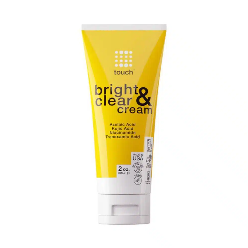 Front-facing photo of a 60 ml white jar of Touch Bright & Clear Cream on a pure white background, showing the green-and-gold label that highlights “15 % Azelaic, Niacinamide, Kojic & Tranexamic Acid” and “Dermatologist-Inspired Dark Spot Corrector” branding.