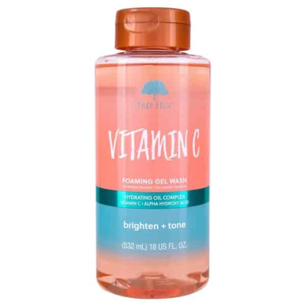 Clear bottle of Tree Hut Vitamin C Foaming Gel Wash (18 fl oz) standing upright on a white background; label features orange-yellow accents and citrus imagery, showcasing the brightening, vitamin C-infused body wash for radiant, hydrated skin.